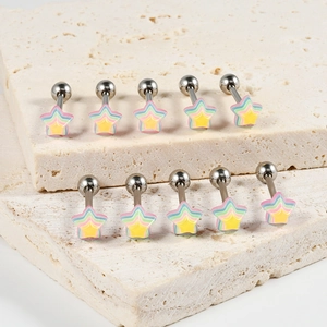 Macro shot of rainbow star piercing studs with steel bars on a stone texture background