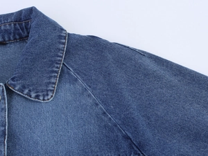 Detail of denim cape jacket showing high-quality stitching on collar and shoulder areas