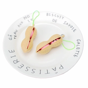 Macro d'un jouet anti-stress cacahuète avec cordon vert sur une assiette blanche