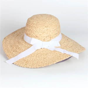 Wide brim raffia straw sun hat for women featuring a white bow ribbon for beach vacations