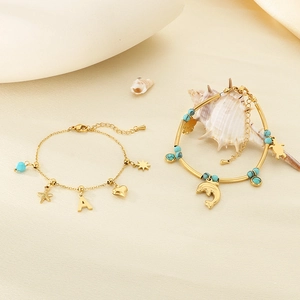 Bracelets dorés océan avec breloques étoile de mer, tortue et perles turquoises sur sable