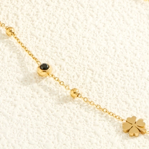 Élégant collier en acier inoxydable doré avec trèfle à quatre feuilles et gemme noire