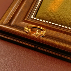 Détail d'une bague dorée avec cristaux sur velours vert dans un cadre vintage