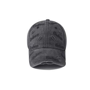Detail of distressed grey denim baseball cap featuring Kindness embroidery and ripped texture
