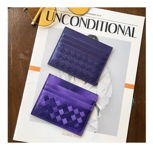 Two purple woven sheepskin card holders shown on a magazine with fashion accessories
