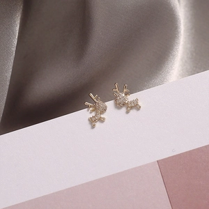 Elegant gold reindeer stud earrings with crystal pave on a silk background