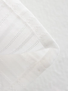 Detailed macro view of white cotton-linen fabric with professional hem stitching work