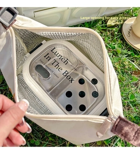 Detail view of cream insulated lunch bag with thick aluminum foil lining and meal box