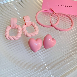 Detailed set of three pink twisted square, hoop, and heart-shaped stud earrings