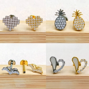 Macro detail of geometric pineapple and heart labret studs with zircon inlays