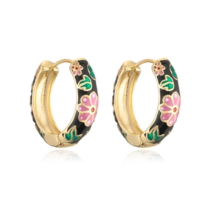 Detailed macro of gold hoops with black enamel and hand-painted floral pattern details