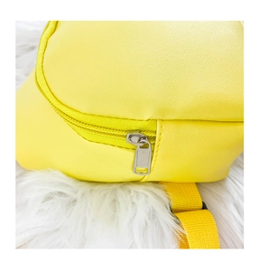 Detailed close-up of yellow PU leather bag showing metal zipper and woven shoulder strap