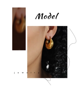 Détail des boucles d'oreilles créoles dorées vintage avec texture croissant et éclat métal