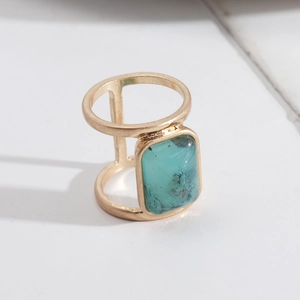Macro detail of bohemian gold-finished ring with rectangle turquoise stone