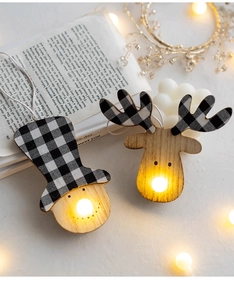 Illuminated wooden Christmas ornaments with snowman and elk on a decorative book