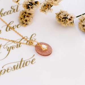 Macro detail of natural strawberry quartz and opal pendant on a 925 silver gold chain