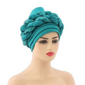Close-up of turquoise turban with braided twist texture and sparkling sequin details