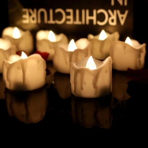 Close-up of LED flameless candles with warm yellow flicker and romantic red petals