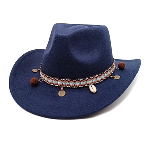 Detail of navy felt cowboy hat featuring ethnic braided band with shell and bronze charms