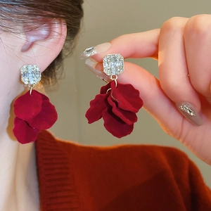 Detail of red flocked flower earrings with crystal studs and gold metal accents