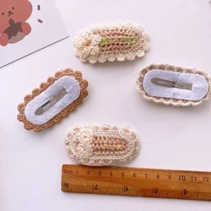 Close-up of a 6cm handmade knitted flower hair clip with metal BB grip and soft lining