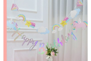 Close-up of holographic Happy Birthday banner with pastel unicorn and rainbow pennants