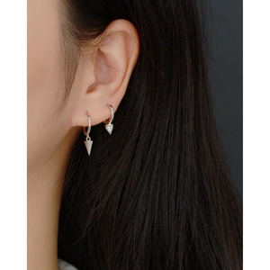 Close-up of woman wearing silver S925 geometric cone earrings with zircon stones