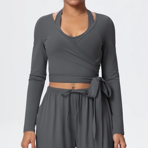 Detail of dark grey yoga set featuring wrap-style long sleeves and tie-up design