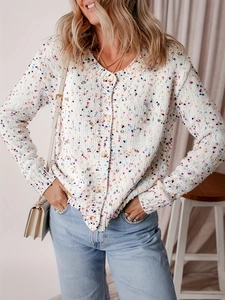 Dettaglio di maglione in maglia a pois colorati con scollo a V e bottoni in legno su bianco