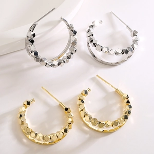 Gold and silver C-shaped geometric hoop earrings with polished faceted metal texture