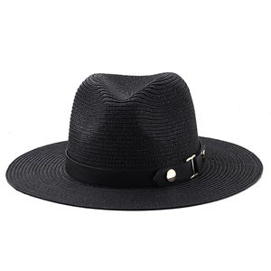 Close-up of black straw fedora hat featuring a matte leather band and gold metal buckle