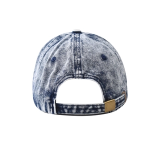 Detail view of the adjustable brass metal buckle and acid wash texture on denim cap