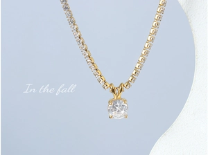 Detail of 18K gold plated necklace with a clear zircon pendant on a tennis chain