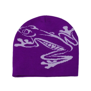 Detail of purple knitted beanie featuring abstract frog pattern in soft acrylic material