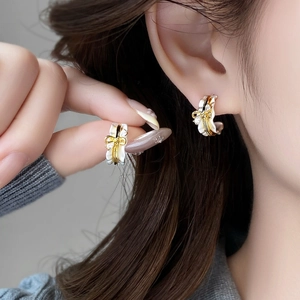 Elegante 18k vergoldete Schleifenohrringe mit weißem Emaille und Diamanten an Model