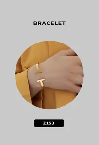 Bracciale a polsino aperto in finitura dorata con design minimalista a doppia T lucida
