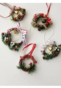 Detail view of mini Christmas wreaths with pine cones, red berries and metal bells