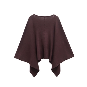 Dettaglio ravvicinato della trama in maglia a coste marrone scuro su poncho chic con scollo a V