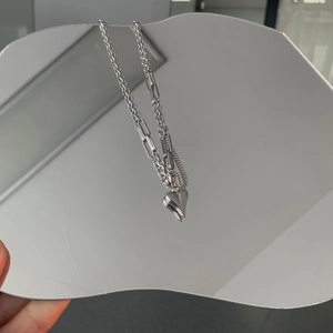 Détail du collier à pendentif cœur argenté avec texture de chaîne multicouche