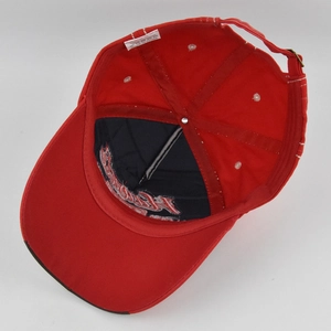Detailed interior of red cotton baseball cap featuring metal buckle and premium embroidery