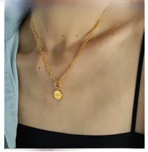Detailed close-up of golden OT buckle necklace with Beloved engraved round pendant