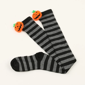 Close-up of Halloween over-knee socks with black stripes and 3D plush pumpkin detail