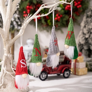 Detail of DIY Christmas gnome ornaments with knitted hats and embroidered letters on tree
