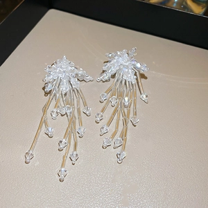Detailed view of long cascading glass bead tassels on elegant fabric flower earrings