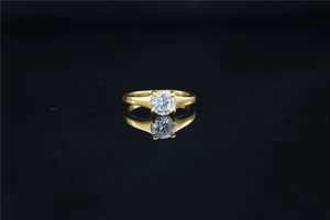 Detailed view of single round-cut moissanite stone in classic four-prong gold setting