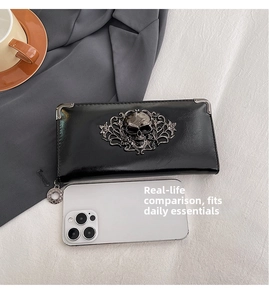 Detailed macro view of punk skull embossment on black glossy leather wallet with metal corners