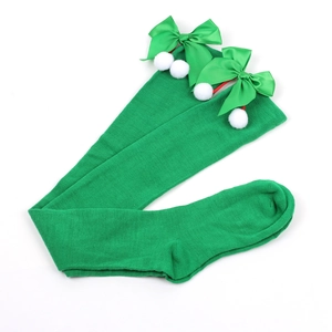 Detail of Christmas green over-knee socks with satin bow and white plush pom poms