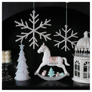 Close-up of sparkling white glitter Christmas tree and rocking horse festive ornaments