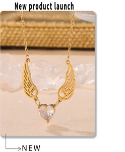 Detail of angel wing pendant necklace with heart-shaped zircon and gold-plated chain