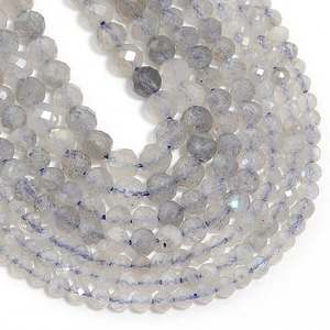 Macro shot of faceted grey labradorite stone beads showing characteristic blue flash and glow